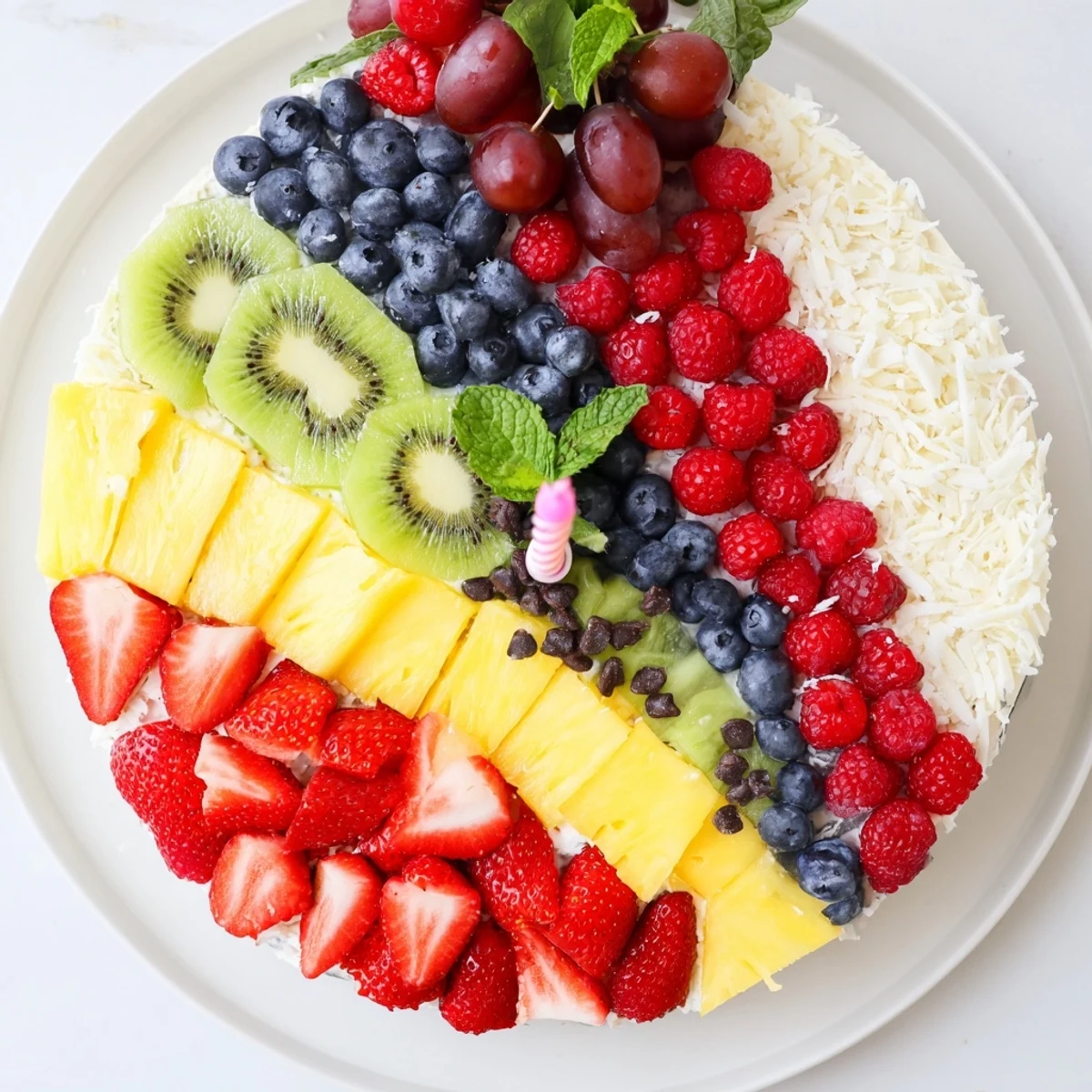 Festive Birthday Board fruit platter slice: colorful strawberries, kiwi, and grapes arranged creatively.
