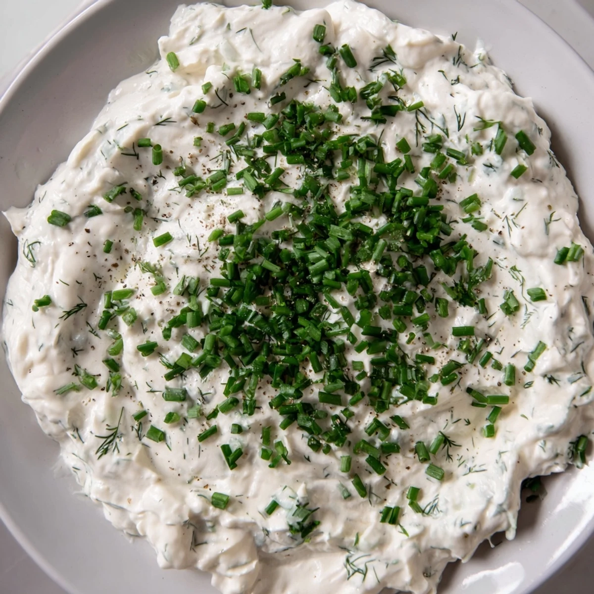 Close-up of a bowl filled with Veggie Ranch Dip, ready to be served with colorful veggie sticks.