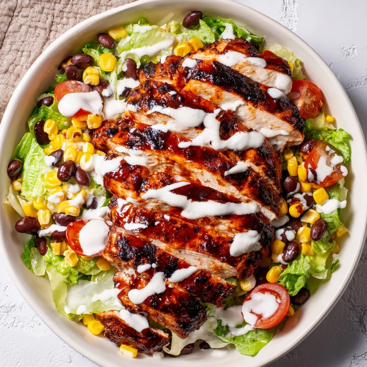 Gesättigte BBQ Hähnchen-Salat mit Ranch-Dressing, gegrilltem Mais, schwarzen Bohnen und frischem Avocado auf romatischem Salat.