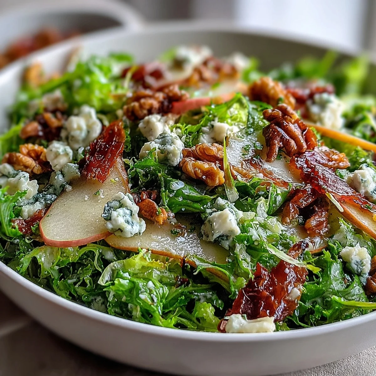 Knuspriger Frisée-Salat mit Birne, Blauschimmelkäse und Prosciutto, übergossen mit Vinaigrette.