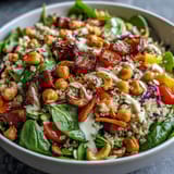 Colorful lunch Rainbow Salad Bowl featuring purple cabbage, chickpeas, and roasted cashews on a rustic wooden table.  