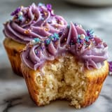 Zwei schillernde, doppelseitige Buttercreme-Wirbel auf fluffigen Vanilla-Cupcakes, bereit zum Servieren.