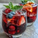 Leuchtend roter Eistee mit hibiskusbeeren und Zitrusfrüchten, perfekt für einen heißen Sommertag.