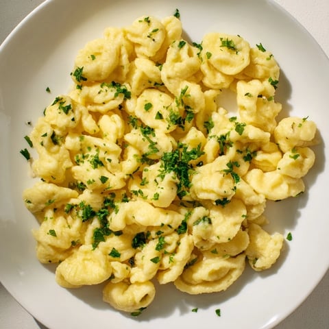 Golden-brown spaetzle, pillowy German noodles bathed in melted butter and fresh parsley.