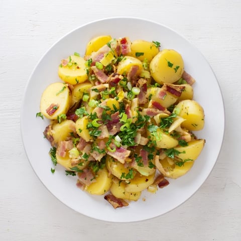 Tender potatoes and crispy bacon highlight this warm German potato salad, ready to serve.