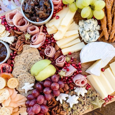 Shining Bright Christmas 2025 Board: A luscious grazing board displays cheeses, charcuterie, fruits, and treats for festive sharing.