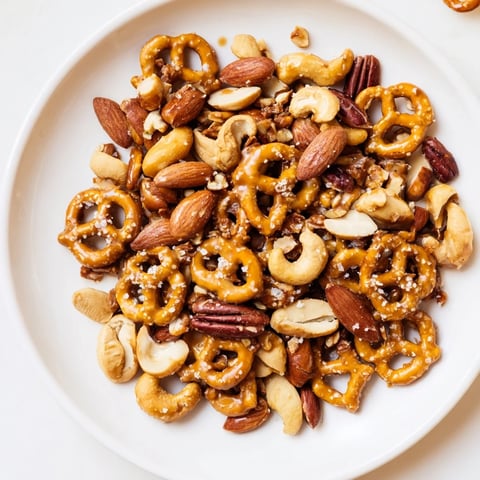 Golden, glossy salted caramel pretzels and nuts snack, ready to be enjoyed as a sweet treat.