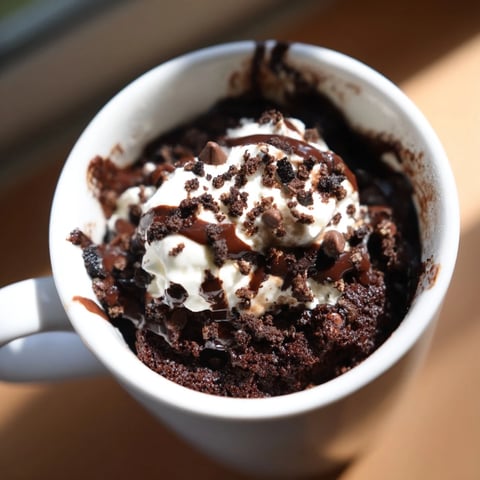 Fudgy Oreo Mug Cake with whipped cream, perfect for a quick and easy dessert.