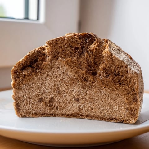 A rustic loaf of Latvian Rupjmaize bread, dark crust contrasted with flavorful caraway seeds.