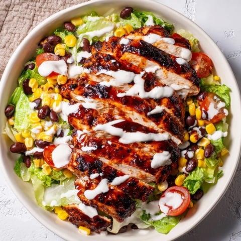 Gesättigte BBQ Hähnchen-Salat mit Ranch-Dressing, gegrilltem Mais, schwarzen Bohnen und frischem Avocado auf romatischem Salat.