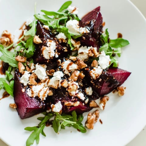 Ein farbenfroher Teller mit gebratenen Rote-Bete-Würfeln, cremigem Ziegenkäse, röstaromen Walnüssen und peppigem Rucola, verfeinert mit Balsamico-Vinaigrette.