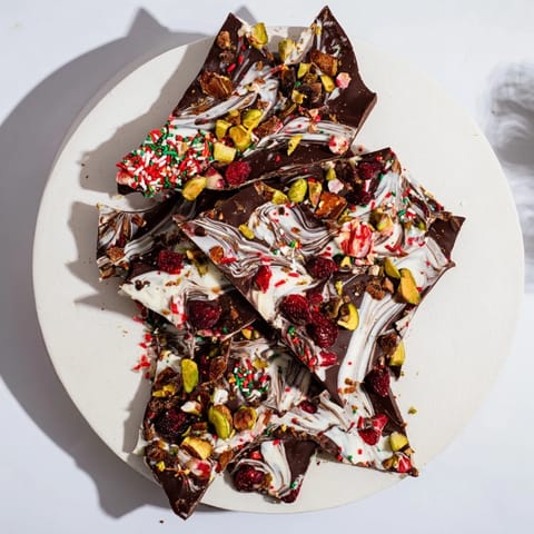 Irregular pieces of Holiday Bark Shard display, showcasing rich chocolate and crunchy toppings.