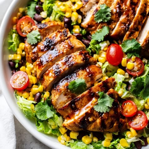 Grilled honey lime chicken sliced over a fresh romaine salad with corn, beans, avocado, and crispy tortilla strips.