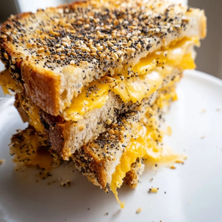 Knuspriges, goldbraunes Everything Bagel Grilled Cheese mit geschmolzenem Käse, perfekt zum Mittagessen.